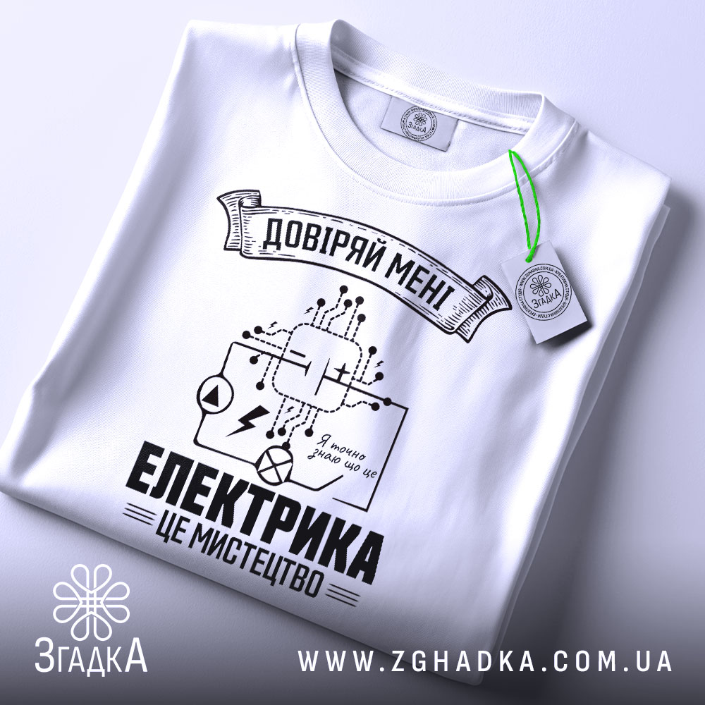 Футболка електрика мистецтво, біла, складена на поверхні, фон світло-сірий, принт чорного кольору з елементами електричних схем і написом 'ЕЛЕКТРИКА ЦЕ МИСТЕЦТВО', на комірці видна етикетка.