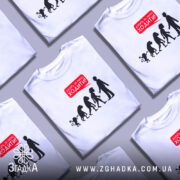 Футболка еволюція досить ходити. Біла футболка з коротким рукавом, зображена на манекені, фон сірий. Принт у вигляді силуетів еволюції з текстом червоного кольору 'Досить за мною ходити!'.