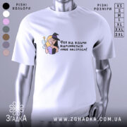 Футболка фея або відьма, білого кольору, зображена з фронтального ракурсу на манекені, фон світлий, принт з ілюстрацією феї та відьми, текст українською мовою.