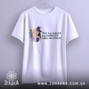 Футболка фея або відьма, білого кольору, зображена з фронтального ракурсу на вішалці, фон світлий, принт з ілюстрацією феї та відьми, текст українською мовою.