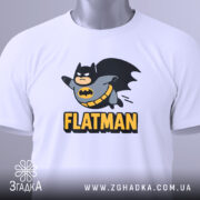 Футболка флетмен білого кольору, складена на поверхні, з видимим ярликом, фон світло-сірий, принт з персонажем у костюмі Бетмена, що летить, з написом 'FLATMAN' під ним.