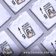 Футболка фото на паспорт: біла футболка на манекені, з принтом, що містить малюнок усміхненої людини з довгим волоссям, яка показує знак миру, текст "МОЄ ФОТО НА ПАСПОРТ:" розташований зверху, фон світло-сірий.