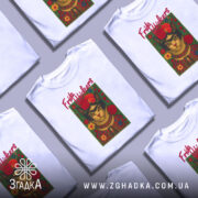 Футболка Фріда стиль, біла, зображена на манекені, фон світло-сірий, принт з котом у стилі Фріди Кало з червоними квітами та написом 'Frida Whiskers'.