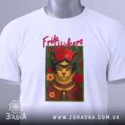 Футболка Фріда стиль, біла, складена на столі, фон світло-сірий, принт з котом у стилі Фріди Кало, з червоними квітами та написом 'Frida Whiskers', на етикетці зелена стрічка.