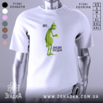 Футболка фу люди. Біла футболка з принтом, на якому зображений зелений персонаж з чашкою в руці. Фон світлий, ракурс зліва, деталі принта чіткі, текст поруч з персонажем: 'ФУ... ЗНОВУ ЛЮДИ!'