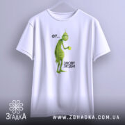 Футболка фу люди. Біла футболка, підвішена на вішалці, з принтом зеленого персонажа. Фон світлий, ракурс спереду, текст на принті: 'ФУ... ЗНОВУ ЛЮДИ!'