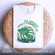 Футболка Glorbo Fruttodrillo білого кольору, зображена зверху на плетеній кошику, фон світлий, принт з зеленим крокодилом, що сидить на воді, з елементами природи, видна частина комірця.