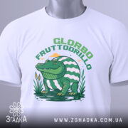 Футболка Glorbo Fruttodrillo білого кольору, зображена в горизонтальному положенні, фон світлий, принт з зеленим крокодилом, що сидить на воді, з елементами природи, на комірці видно етикетку з зеленим шнурком.