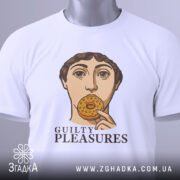 Футболка guilty pleasures, біла, зображена на столі, ракурс зверху, фон світло-сірий, принт з обличчям людини, що тримає печиво, текст 'GUILTY PLEASURES' під принтом, на футболці є бірка.