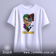 Футболка гарлі джокер білого кольору, підвішена на вішалці, з принтом, що зображає Джокера та Харлі Квін, з текстом 'HER JOKER', фон світло-сірий.