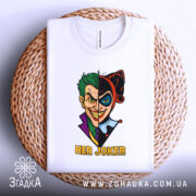 Футболка гарлі джокер білого кольору, розкладена на плетеному кошику, з принтом, що зображає Джокера та Харлі Квін, з текстом 'HER JOKER', фон світло-сірий.