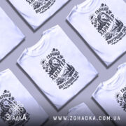 Футболка гарний характер, біла, зображена на манекені з правого боку, фон світло-сірий, принт чорного кольору з зображенням лева, гір, річки та квітів.