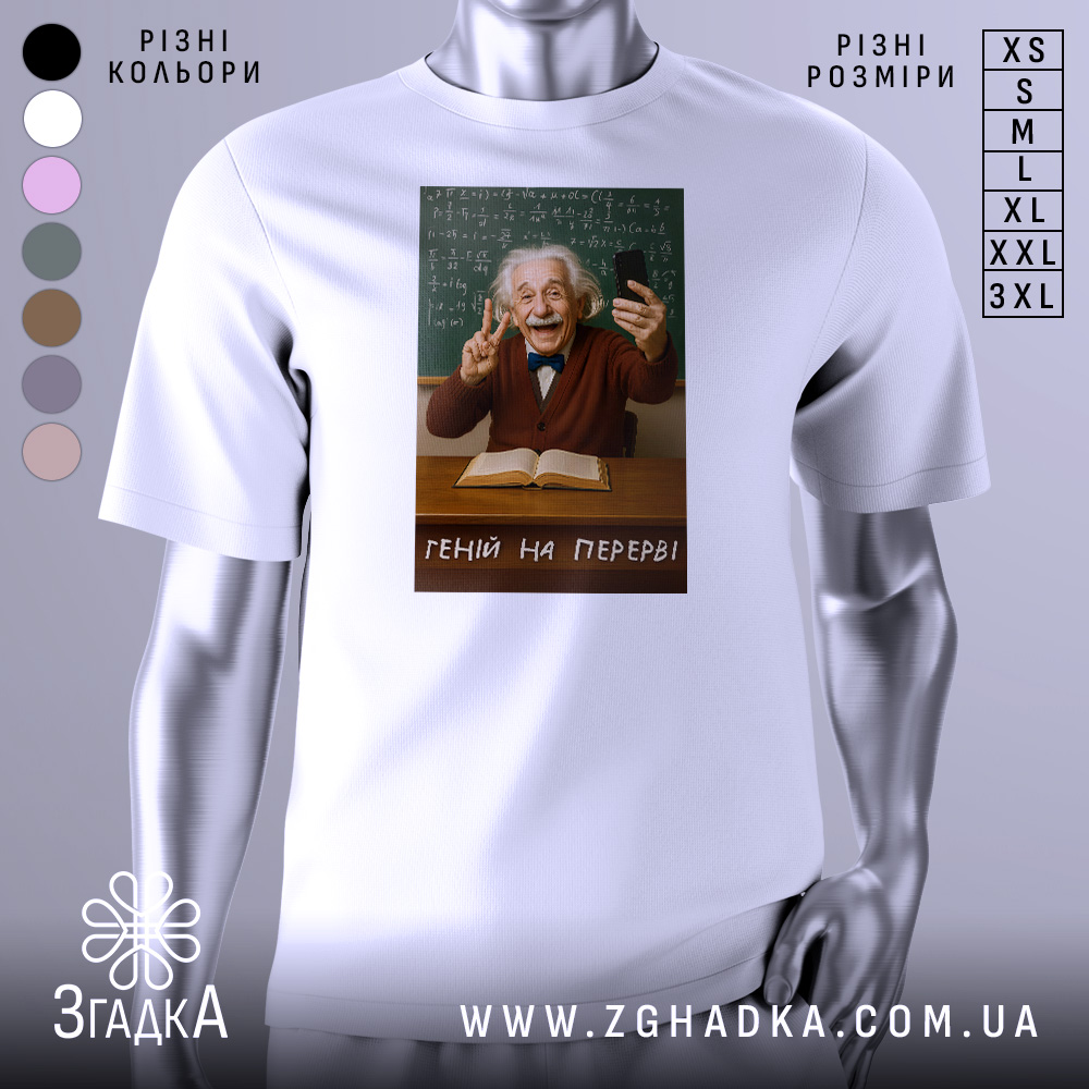 Футболка геній на перерві. Біла футболка з принтом, на якому зображений усміхнений чоловік з сивим волоссям, що тримає телефон і показує знак миру. Фон складається з зеленої дошки з формулами, а на столі лежить відкрита книга. Текст на футболці: 'ГЕНІЙ НА ПЕРЕРВІ'.