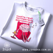 Футболка генії потребують відпочинку, біла, зображена зверху, на фоні світло-сірого кольору, принт з малюнком мозку в окулярах, що сидить у кріслі, текст червоним шрифтом, етикетка з зеленим шнурком.