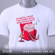 Футболка генії потребують відпочинку, біла, зображена зверху, на фоні світло-сірого кольору, принт з малюнком мозку в окулярах, що сидить у кріслі, текст червоним шрифтом, етикетка з зеленим шнурком.