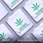 Футболка герб нової свідомості, біла, зображена з правого боку на манекені, фон світло-сірий, принт зелений з зображенням листа коноплі та текстом українською мовою.