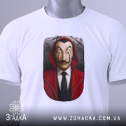 Футболка герой у масці, біла, зображена з верхнього ракурсу, фон світлий, принт з обличчям героя в червоному капюшоні, на футболці є етикетка.