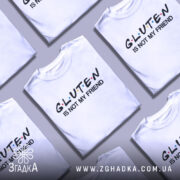 Футболка глютен білого кольору, зображена з фронтального ракурсу на манекені, фон світло-сірий, принт чорного кольору з написом 'GLUTEN IS NOT MY FRIEND' та кольоровими крапками.