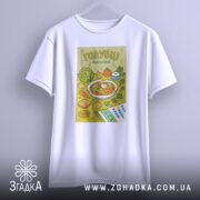 Футболка голубці білого кольору, підвішена на вішалці, фон світло-сірий, принт з малюнком голубців, овочів та інших страв, оформлений у яскравих кольорах.