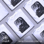 Футболка Горила Діджей білого кольору, зображена на манекені, фон світло-сірий, принт з горилою в навушниках, що працює на пульті, з пташками на фоні.