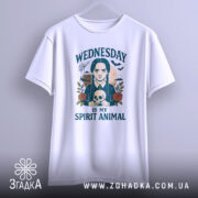 Футболка Готичний Принт, біла, зображена на вішалці, фон світло-сірий, принт з дівчиною з косами, яка тримає череп, текст 'WEDNESDAY IS MY SPIRIT ANIMAL', футболка має вільний крій.