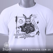 Футболка грайливий небезпечний, білого кольору, зображена зверху, на складеній футболці, фон світло-сірий, принт з чорним малюнком зайця в шкіряному жакеті з написом 'Грайливий? Ні, небезпечний!', з зеленим ярликом.