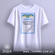 Футболка грамота, біла, підвішена на вішалці, фон світлий, принт з синьо-жовтим гербом України та текстом "ГРАМОТА".