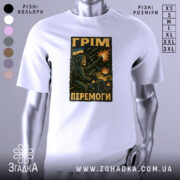 Футболка грім перемоги. Біла футболка з коротким рукавом, зображена на манекені, фон світло-сірий. Принт з військовим персонажем, що стріляє з гармати, на фоні вибухів і українського прапора.