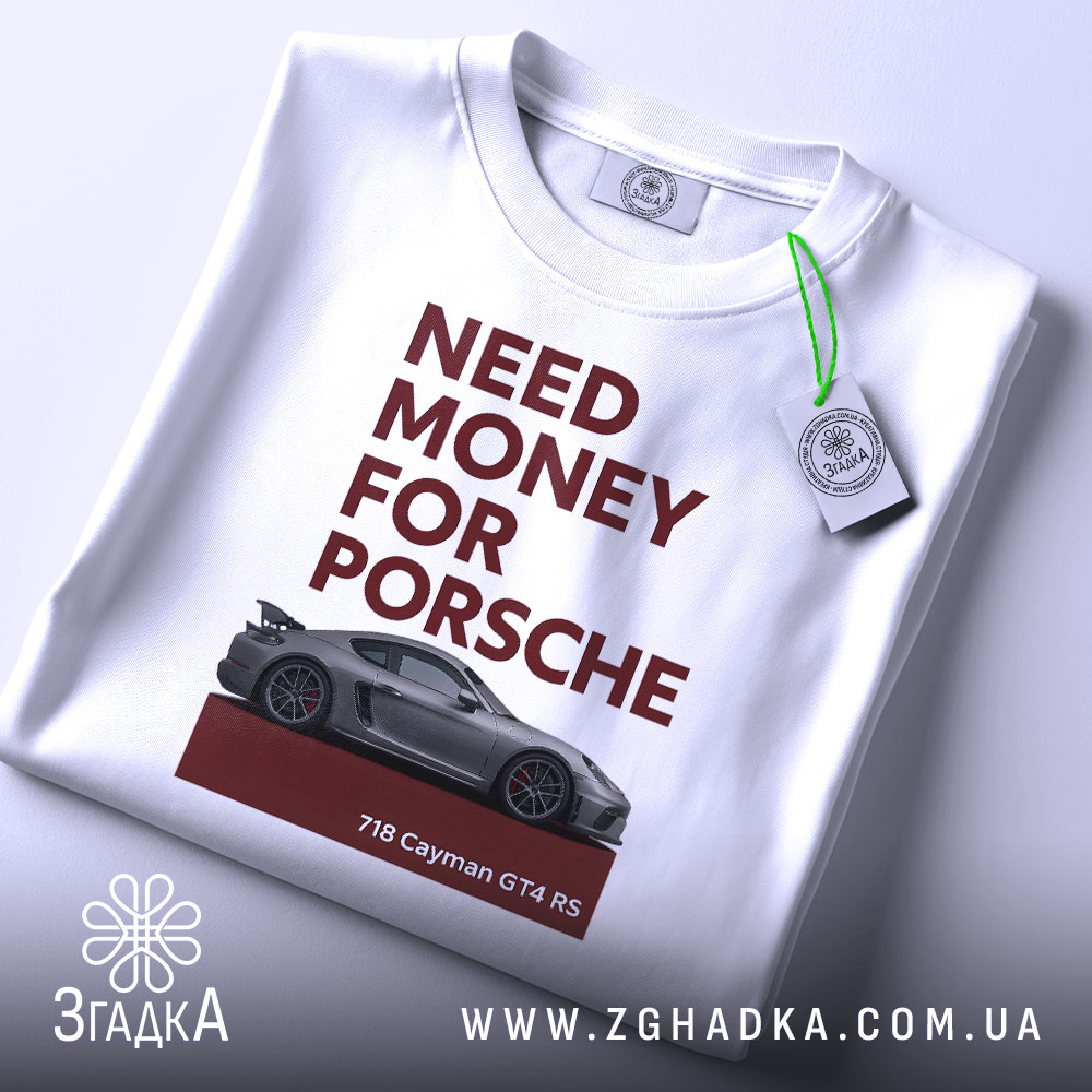 Футболка гроші на Porsche, біла, зображена на столі, фон світло-сірий, принт з текстом 'NEED MONEY FOR PORSCHE' червоного кольору та зображенням автомобіля Porsche 718 Cayman GT4 RS, на комірці є етикетка.