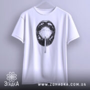 Футболка губи льодяник, біла, підвішена на вішалці, фон світло-сірий, принт чорного кольору з зображенням губ і льодяника.