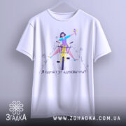 Футболка я адекватна, білого кольору, зображена з фронтального ракурсу на вішалці, фон нейтральний, принт з дівчиною на велосипеді, яка тримає квіти, текст під малюнком: 'Я одна тут адекватна?'.