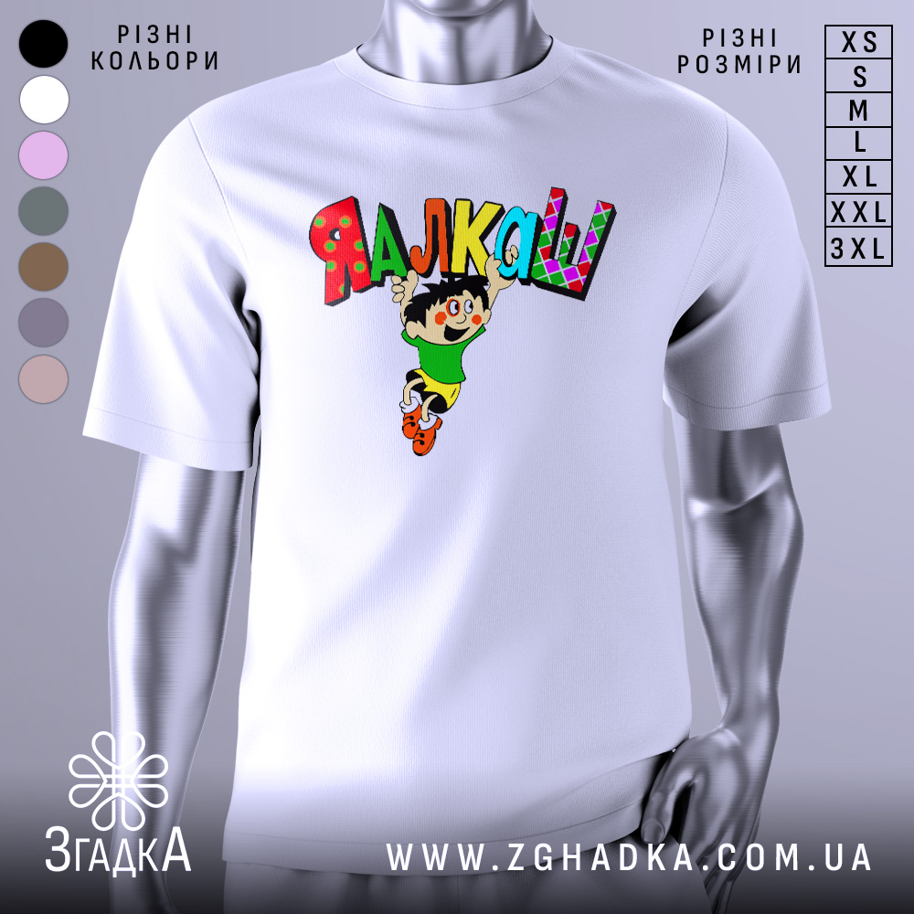Футболка я алкаш. Біла футболка на манекені, з принтом на грудях, що зображує персонажа в зеленій футболці та жовтих шортах, який стрибає з написом 'ЯЛКАШ' кольоровими літерами. Фон світло-сірий.
