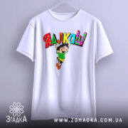Футболка я алкаш. Біла футболка, підвішена на вішалці, з принтом на грудях, що зображує персонажа в зеленій футболці та жовтих шортах, який стрибає з написом 'ЯЛКАШ' кольоровими літерами. Фон світло-сірий.