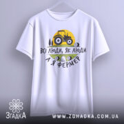 Футболка я фермер. Біла футболка з коротким рукавом, підвішена на вішалці, фон світло-сірий. Принт містить жовте сонце, чорний трактор та текст "ВСІ ЛЮДИ, ЯК ЛЮДИ А Я ФЕРМЕР" у чорному та зеленому кольорах.