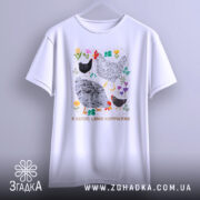 Футболка я керую цими курочками. Біла футболка з коротким рукавом, зображена з фронтального ракурсу на світло-сірому фоні. Принт містить малюнки курей та квітів, виконаний у яскравих кольорах, з текстом внизу.