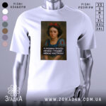 Футболка я людина проста. Біла футболка з принтом, зображення розташоване по центру. На принті зображена дівчина з темним волоссям та червоною стрічкою, яка виглядає сумною. Текст на принті чорного кольору, розташований під зображенням. Фон футболки світлий, без додаткових елементів.