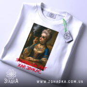 Футболка я прийшла білого кольору, зображена на плоскій поверхні, фон світло-сірий, принт з портретом жінки в окулярах, яка тримає сигарету, з текстом червоного кольору під малюнком, на футболці є етикетка.