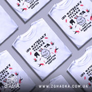 Футболка я та жертви, біла, зображена з правого ракурсу, на фоні світло-сірого градієнту, принт містить малюнок з персонажем у формі кролика з червоними плямами та текстом.