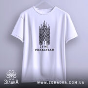 Футболка я українець, білого кольору, підвішена на вішалці, зображена з фронтального ракурсу, фон світло-сірий, принт чорного кольору з написом 'I'M UKRAINIAN' та стилізованими елементами.