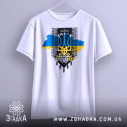 Футболка я українець, біла, підвішена на вішалці, фон нейтральний, принт з тризубом, сині та жовті кольори, текст "Я УКРАЇНЕЦЬ".