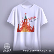 Футболка як воно палає, біла, підвішена на вішалці, фон світло-сірий, принт з червоними і жовтими вогнями, зображення Кремля з годинником і зіркою.