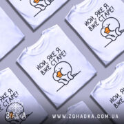 Футболка яке я старе, білого кольору, зображена з фронтального ракурсу на манекені, фон світло-сірий, принт з малюнком пташки з оранжевим дзьобом і текстом 'Йой, яке я вже старе!'.