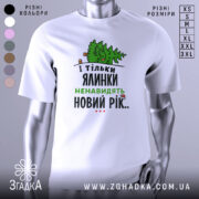 Футболка ялинки новий рік, біла, зображена на манекені з правого боку, фон нейтральний, принт з ялинкою та текстом у зеленому та чорному кольорах.