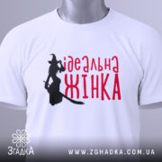 Футболка ідеальна жінка, біла, зображена на манекені, фон світло-сірий, принт з силуетом відьми та написом червоним шрифтом 'ідеальна жінка'.
