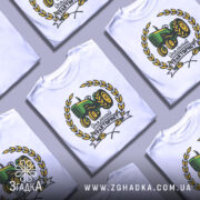 Футболка ідеальний тракторист, біла, зображена на манекені з правого боку, фон світло-сірий, принт з трактором зеленого кольору, оточений жовтими листям і написом 'Ідеальний тракторист'.