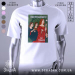 Футболка йди працювати, біла, зображена на манекені, фон світло-сірий, принт з жінками в традиційному одязі, червона сукня, зелений фон з рослинністю, текст "ЙДИ ПРАЦЮВАТИ, ЦЕ ТРАВЛЯ".