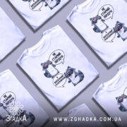 Футболка єнот пердун білого кольору, зображена з фронтального ракурсу на манекені, фон нейтральний. Принт містить двох єнотів у чорних окулярах, один з них говорить 'НЕ СТАРИЙ ПЕРДУН', а інший - 'А ВІНТАЖНИЙ ГАЗОГЕНЕРАТОР'.