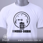 Футболка індикатор пива, біла, складена на столі, фон світло-сірий, принт з індикатором рівня пива та написом 'I NEED BEER' чорного кольору, з етикеткою на рукаві.