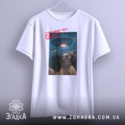 Футболка інопланетяни атакують Землю, біла футболка на вішалці, ракурс спереду, фон нейтральний, принт з двома собаками, що сміються, та космічним кораблем на фоні з українським прапором.