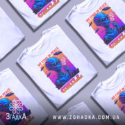 Футболка інопланетний чіл, біла, зображена на манекені, фон світло-сірий, принт з інопланетянином, який курить, кольори принта яскраві: синій, рожевий, оранжевий, текст 'WE COME IN PEACE' і 'CHILL'.